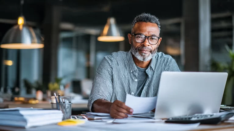 Small business owner using expense tracker software on laptop